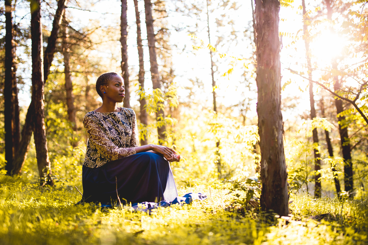Person practicing mindful meditation in a serene forest clearing